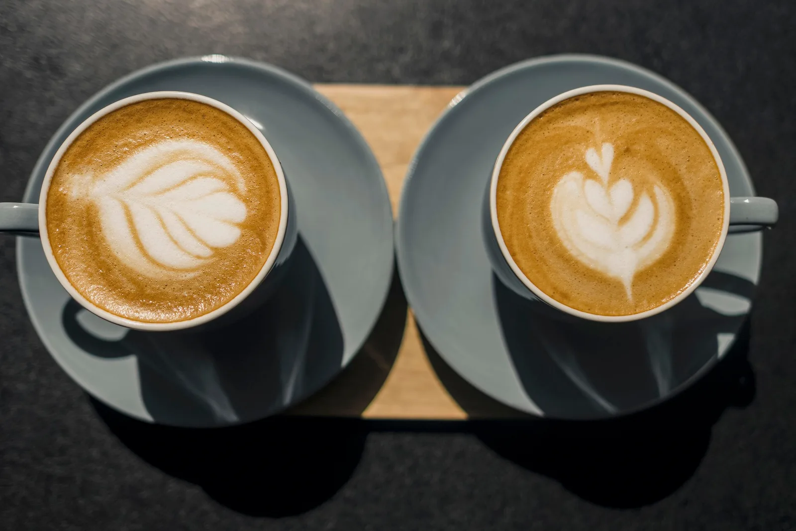Two cappuccinos with latte art, seen from above